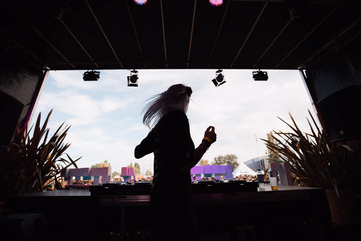 DJ-Silhouette vor Abendhimmel, Hände am Mischpult