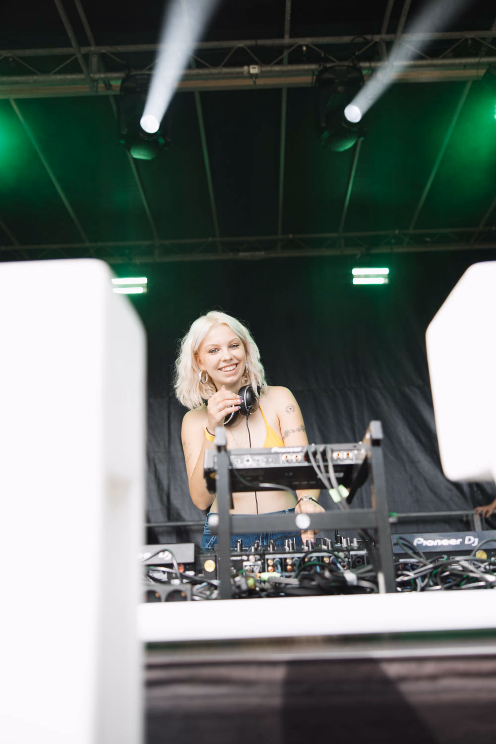 Blonde DJane lächelt hinter dem Plattenteller