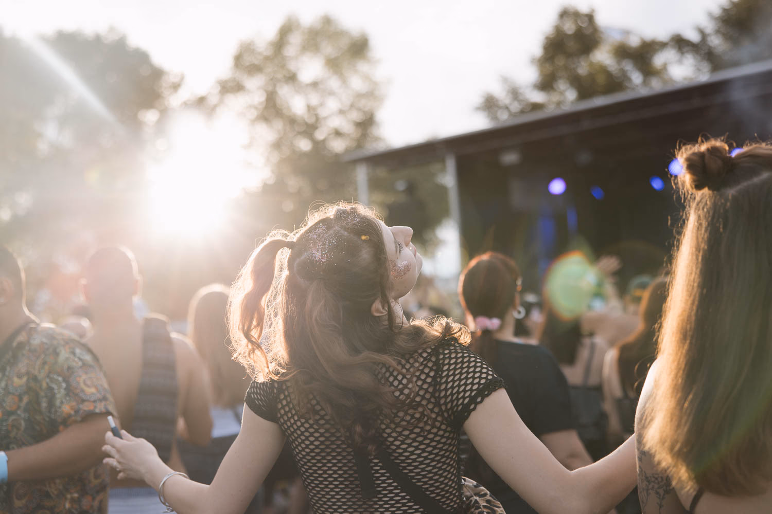 Glitzer im Gesicht, tanzend mit dem Rücken zur Kamera