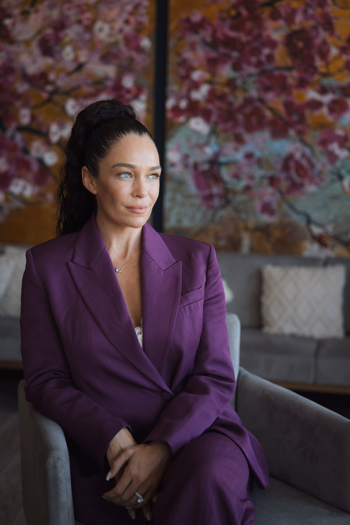 Business-Porträt im violetten Blazer vor Kirschblüten-Kunstwerk