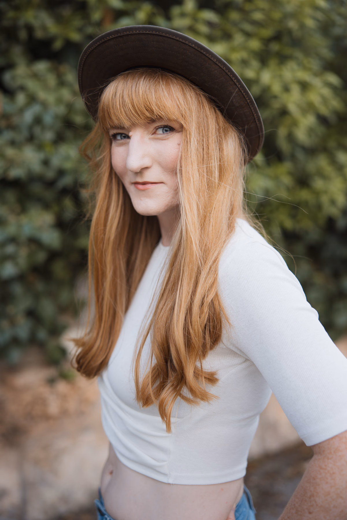 Lässige Pose vor Hecke, Jeans und cropped Top