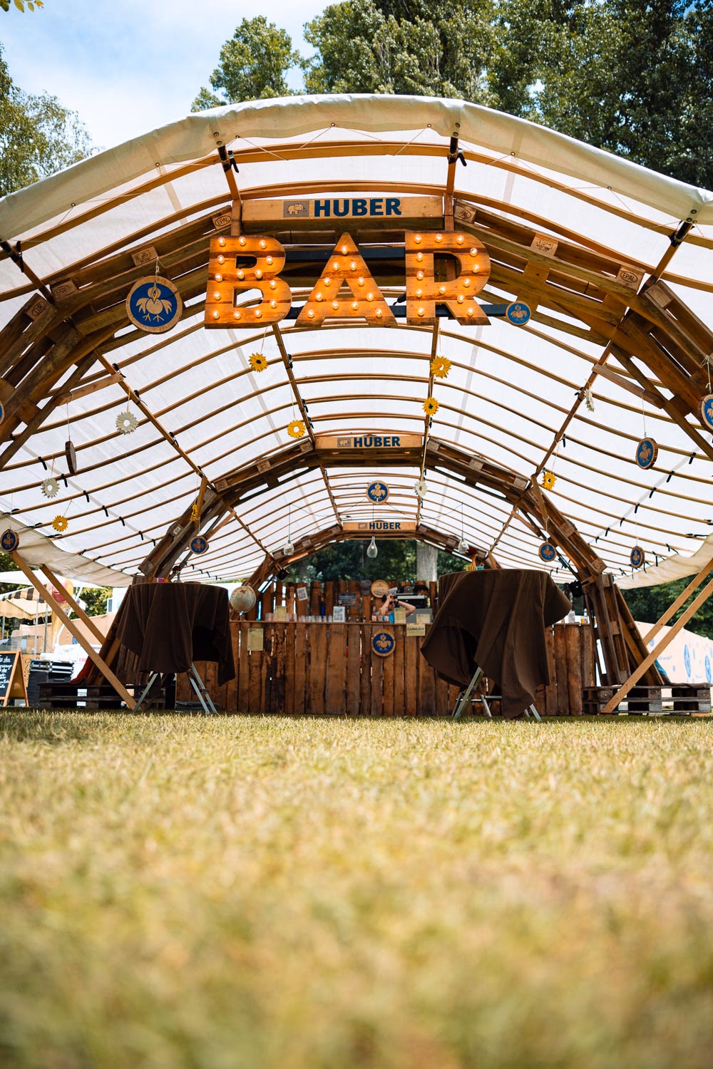 Holzbar mit Lichterkette und Leuchtschrift BAR im Festivalpark