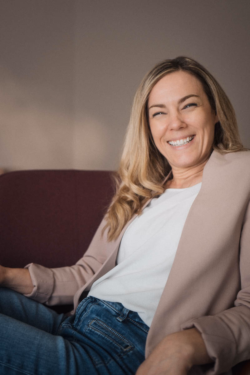 Lächelnde Businessfrau, Blazer, natürliches Fensterlicht